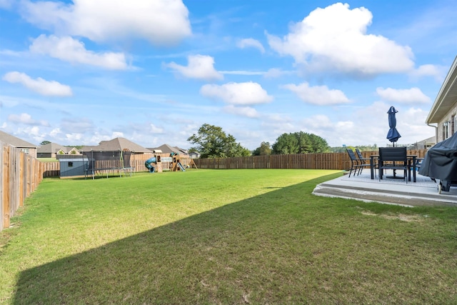 view of yard with a playground, a patio, and a trampoline