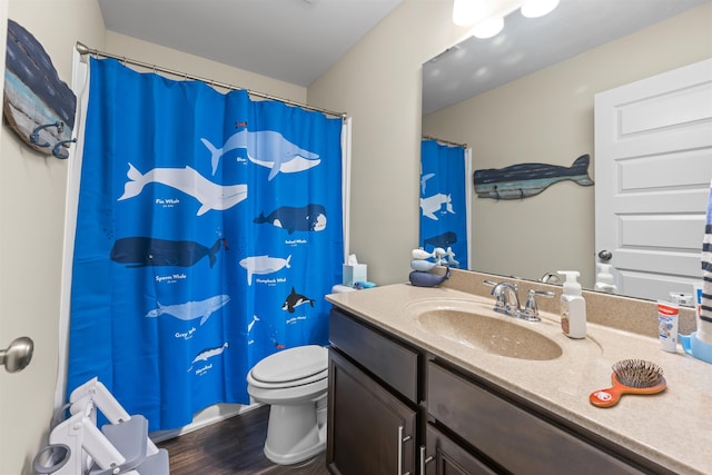 bathroom with hardwood / wood-style floors, vanity, and toilet