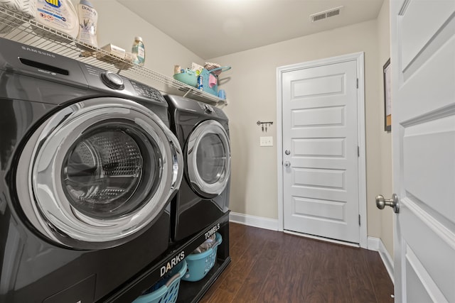 laundry area with dark hardwood / wood-style flooring and washing machine and clothes dryer