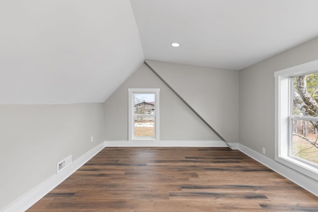 bonus room with plenty of natural light, dark hardwood / wood-style flooring, and vaulted ceiling