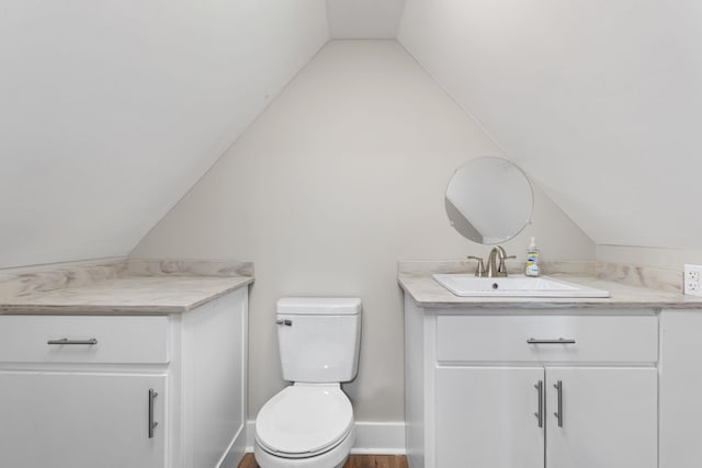 bathroom with vanity, lofted ceiling, hardwood / wood-style floors, and toilet