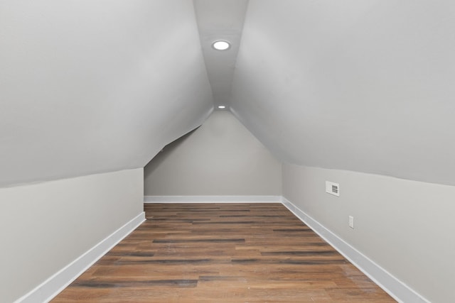 bonus room featuring vaulted ceiling and dark hardwood / wood-style flooring