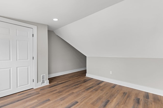 additional living space with vaulted ceiling and dark hardwood / wood-style floors