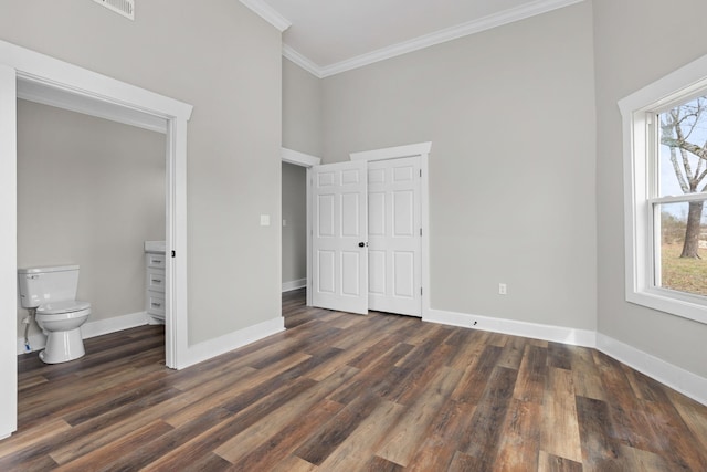 unfurnished bedroom featuring crown molding, dark hardwood / wood-style floors, and a towering ceiling