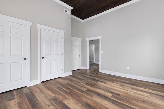 unfurnished bedroom featuring ornamental molding and dark hardwood / wood-style floors