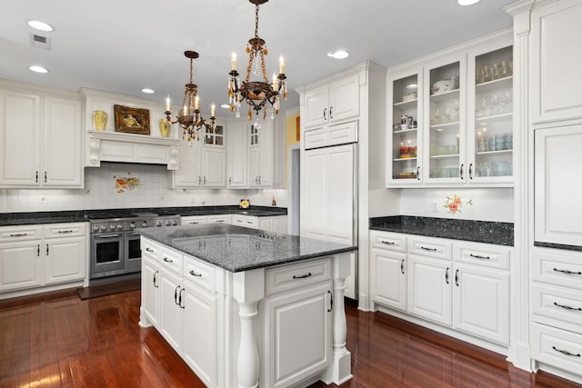 kitchen featuring white cabinets, a center island, double oven range, and hanging light fixtures