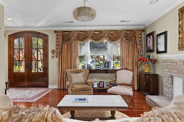 sitting room with french doors, crown molding, and wood-type flooring