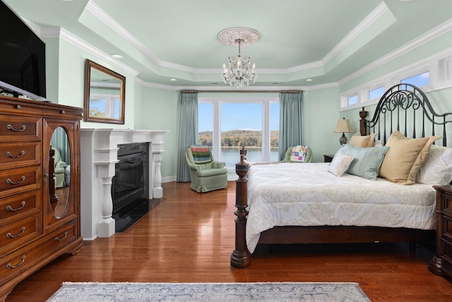 bedroom with dark hardwood / wood-style flooring, a raised ceiling, and ornamental molding