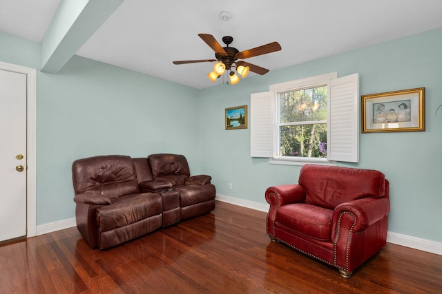 living room featuring ceiling fan, beamed ceiling, and dark wood-type flooring