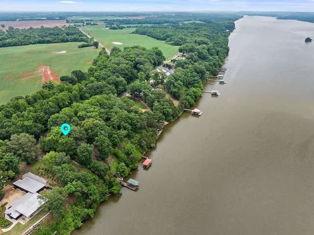 drone / aerial view of a nearby body of water and a tree filled landscape