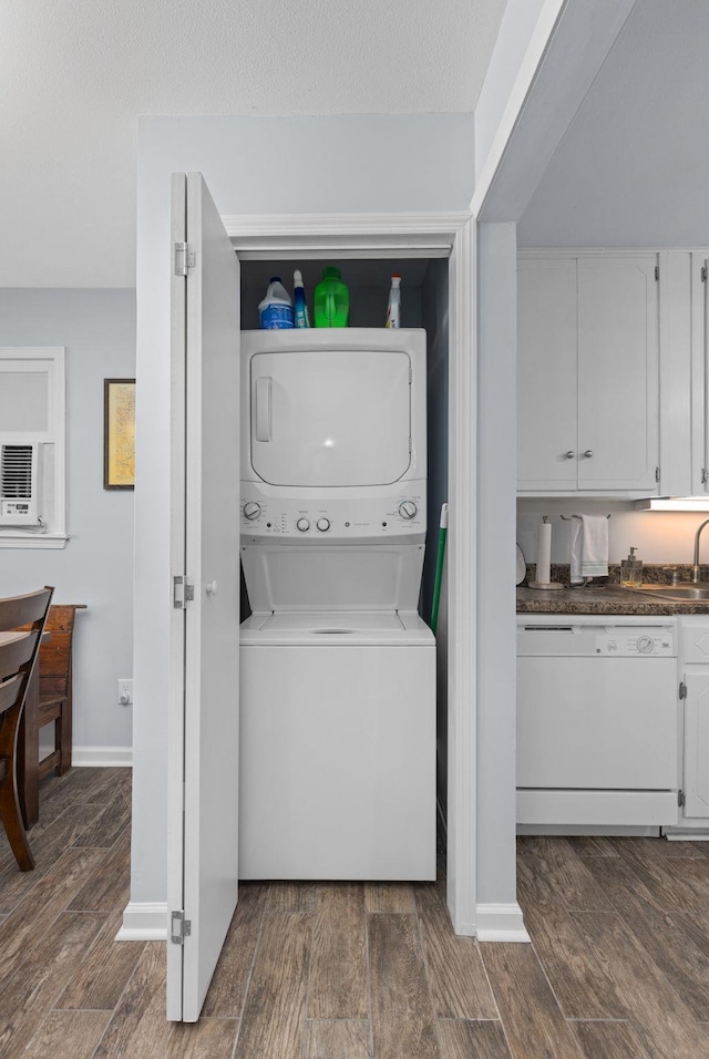 washroom with stacked washer and clothes dryer and dark wood finished floors