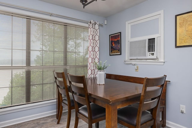 dining space with baseboards and wood finished floors