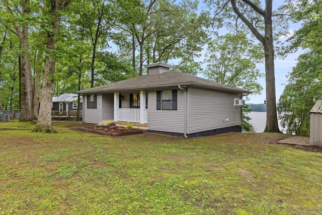view of front of house featuring a front yard, a porch, and roof with shingles