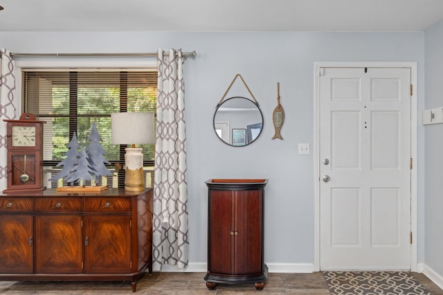 foyer with baseboards and wood finished floors
