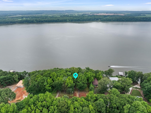 aerial view of property's location with a large body of water and a heavily wooded area