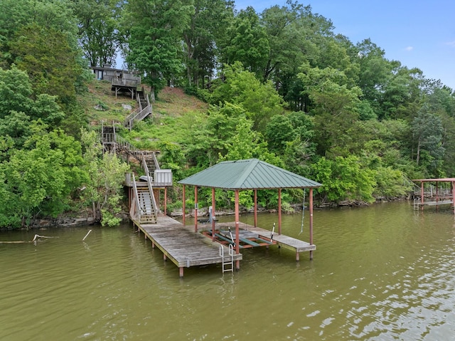 dock with stairs, boat lift, and a water view