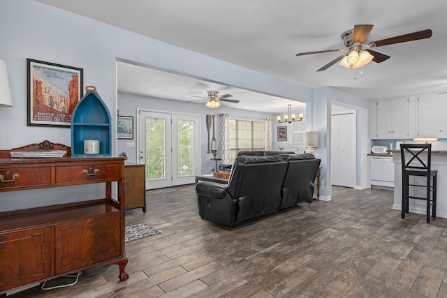 living area with ceiling fan, dark wood finished floors, and a chandelier