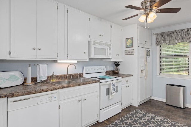 kitchen with white appliances, a sink, dark countertops, and white cabinets