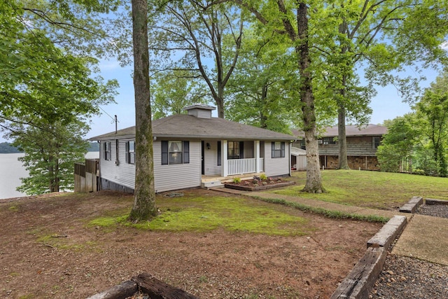 view of front facade featuring covered porch, a chimney, and a front yard