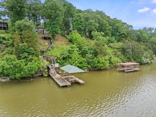 dock area featuring boat lift, stairs, and a water view