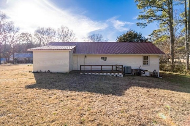  - rear view of property with cooling unit, a deck, metal roof, and a yard