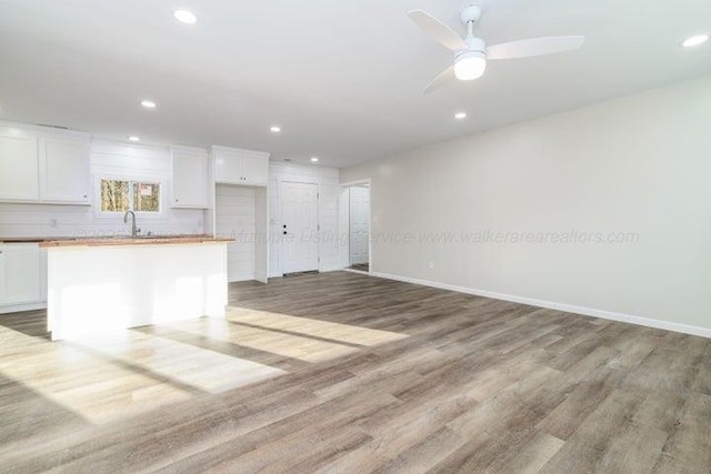  - unfurnished living room featuring light wood-style floors, baseboards, recessed lighting, and ceiling fan