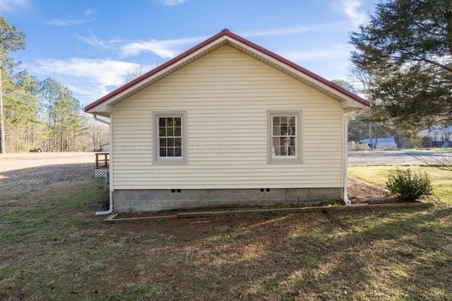  - view of side of home with crawl space and a yard