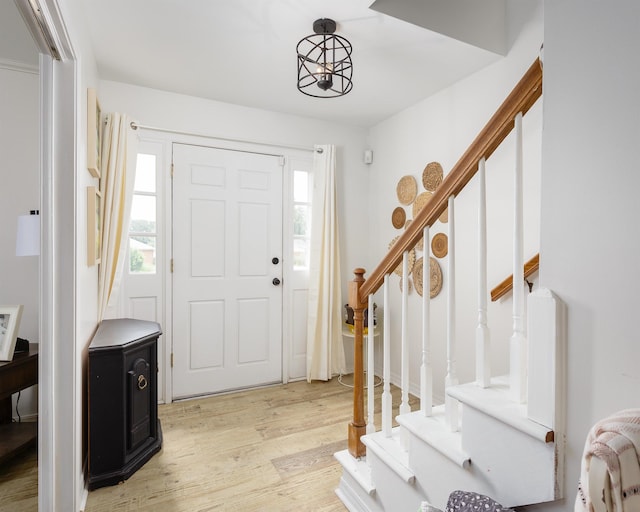 entryway featuring a wealth of natural light, light hardwood / wood-style floors, and an inviting chandelier