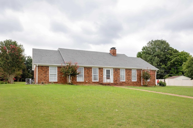 ranch-style house featuring a front lawn and cooling unit