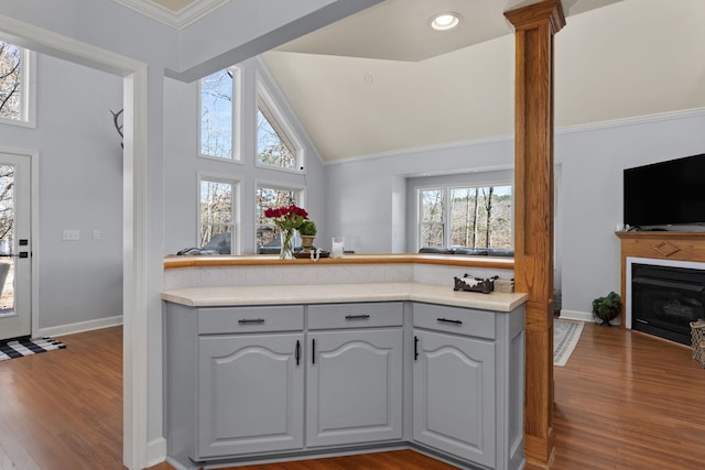 kitchen with gray cabinets, vaulted ceiling, light countertops, and wood finished floors