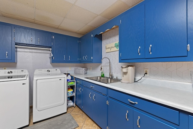 laundry area featuring cabinet space, a sink, washing machine and clothes dryer, and light tile patterned floors