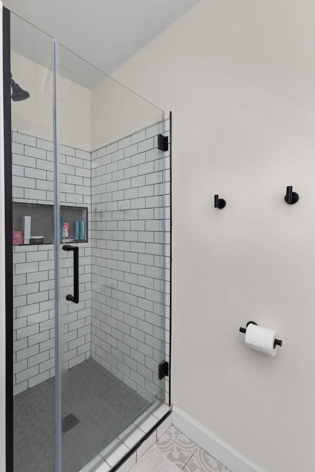 bathroom featuring a stall shower, baseboards, and tile patterned floors