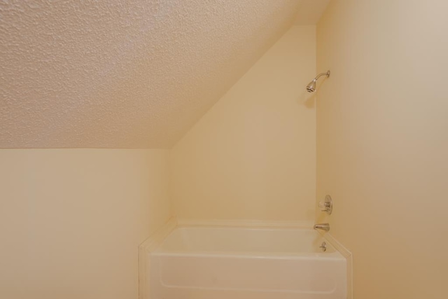 bathroom with a bathtub and a textured ceiling