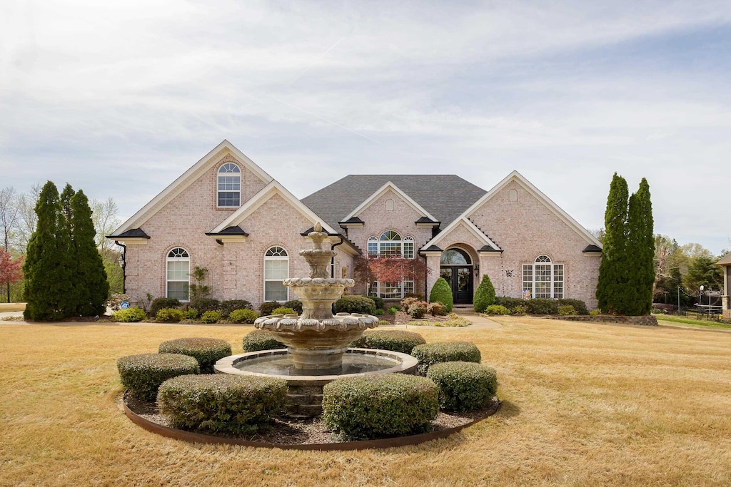 view of front of house with a front yard and brick siding
