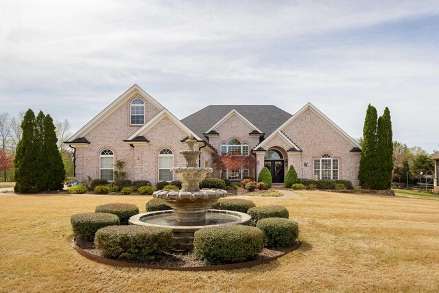 view of front of house with a front yard and brick siding