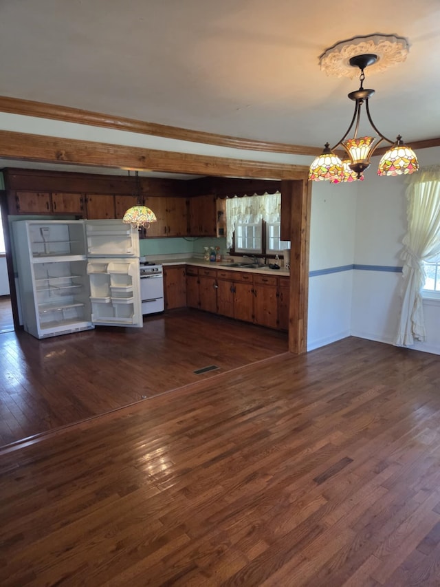 kitchen featuring electric stove, light countertops, dark wood finished floors, and decorative light fixtures