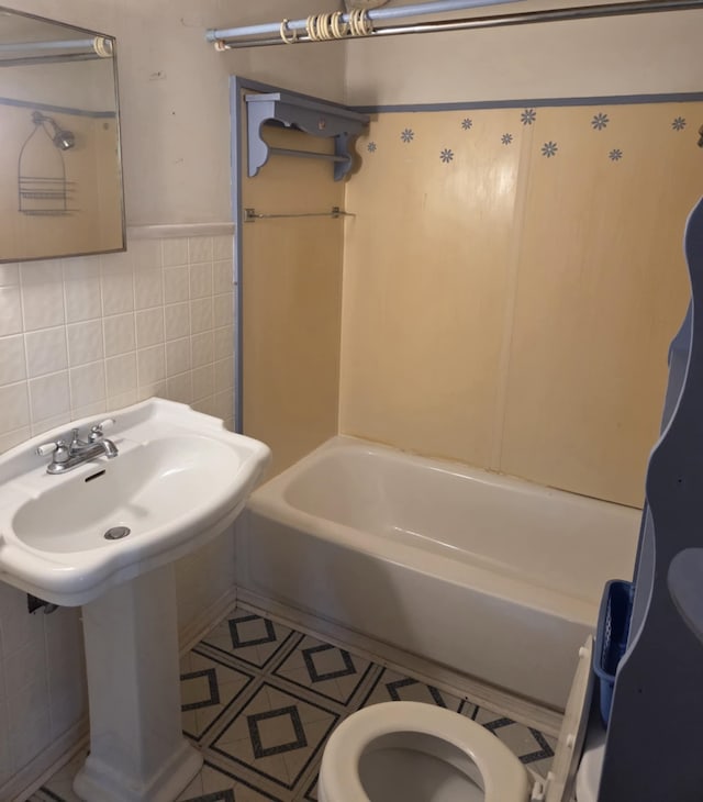 full bathroom featuring tile walls, toilet, and tile patterned floors