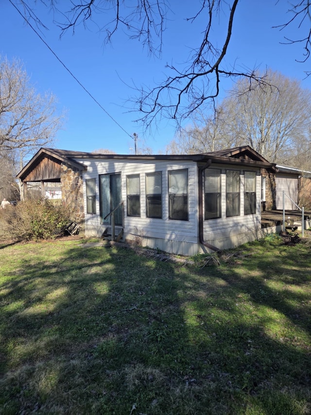 back of house with entry steps and a yard