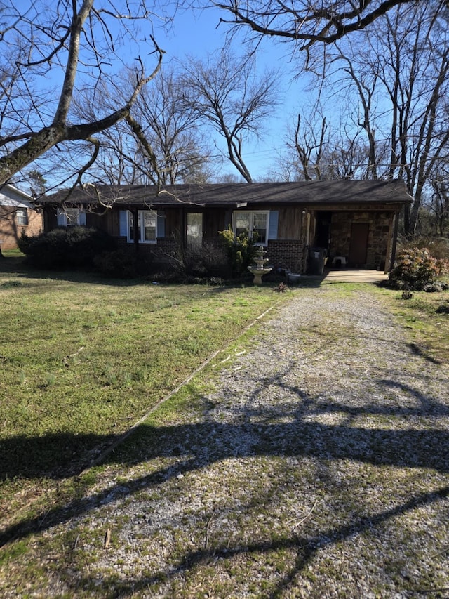 view of front facade with dirt driveway and a front lawn