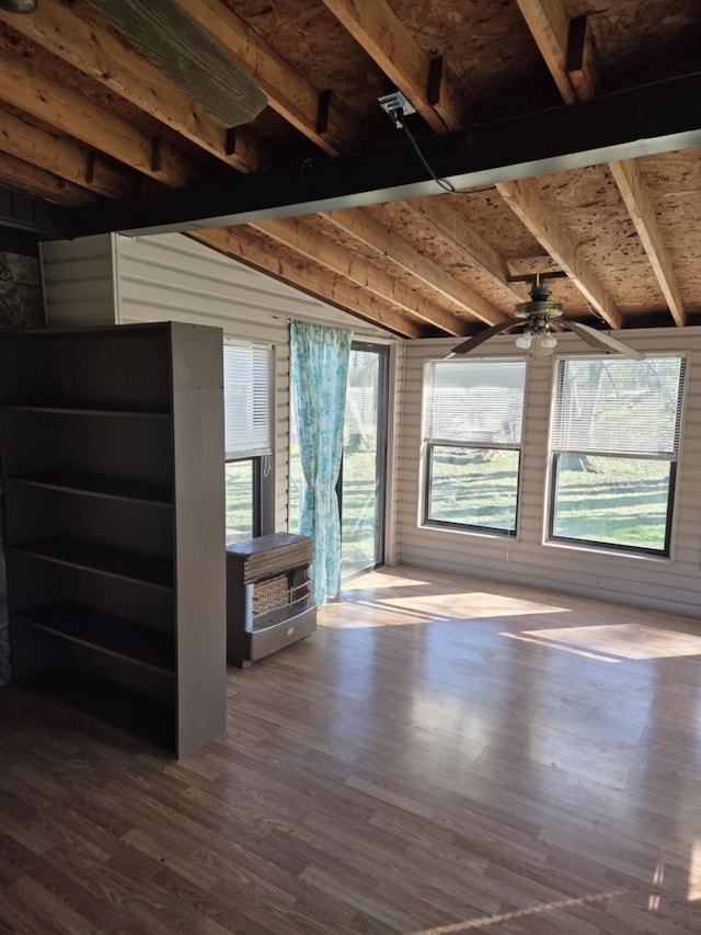 interior space with a ceiling fan, lofted ceiling with beams, and wood finished floors