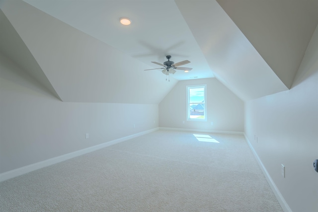 additional living space with vaulted ceiling, carpet flooring, a ceiling fan, and baseboards