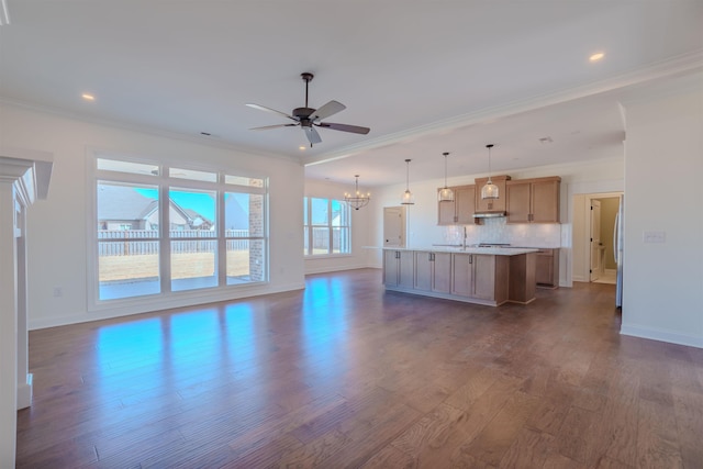 unfurnished living room with recessed lighting, dark wood-type flooring, ornamental molding, baseboards, and ceiling fan with notable chandelier