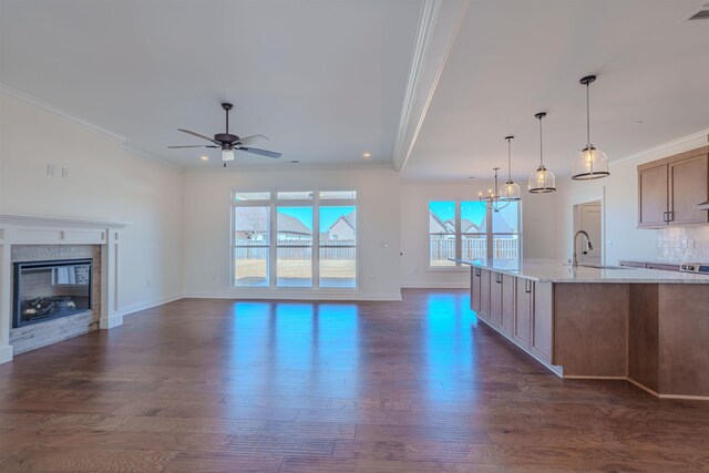 kitchen with light stone counters, stainless steel appliances, a large island, and decorative light fixtures