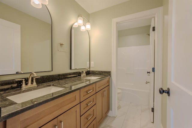 full bathroom featuring marble finish floor, double vanity, a sink, and toilet