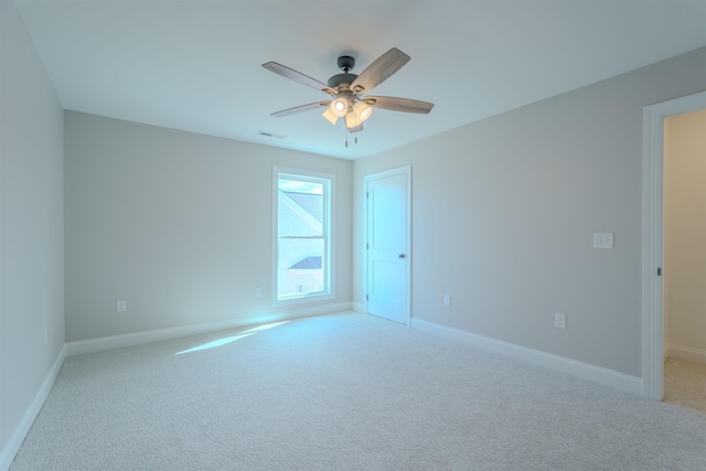 unfurnished room with light carpet, ceiling fan, visible vents, and baseboards