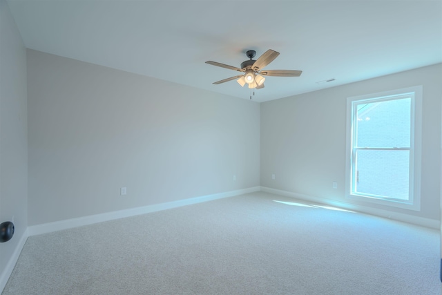 empty room featuring visible vents, carpet, a ceiling fan, and baseboards