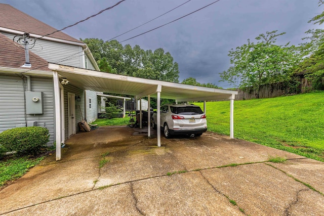  - view of parking featuring concrete driveway and a carport