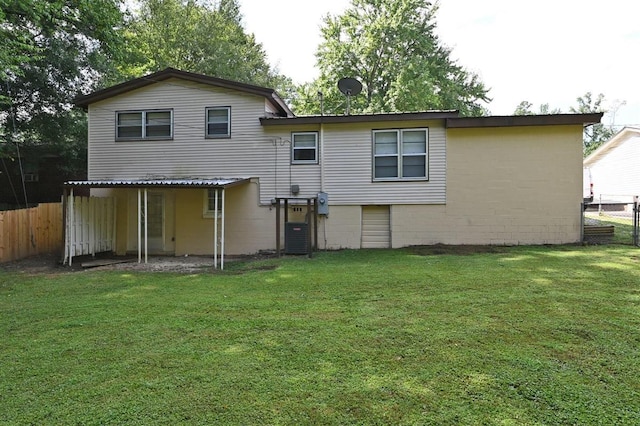 rear view of property with a yard and central air condition unit