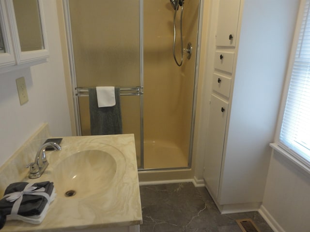 bathroom featuring an enclosed shower and sink