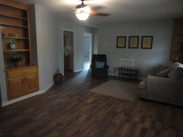 living room featuring ceiling fan and dark wood-type flooring